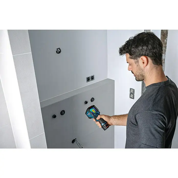 Bosch Professional Wärmebildkamera GTC 12V-450-13 - -20 °C - 450 °C - Ein Mann benutzt eine Bosch Wärmebildkamera, um ein Badezimmer auf potenzielle Probleme zu überprüfen. Die Kamera zeigt Wärmesignaturen zur Inspektion.