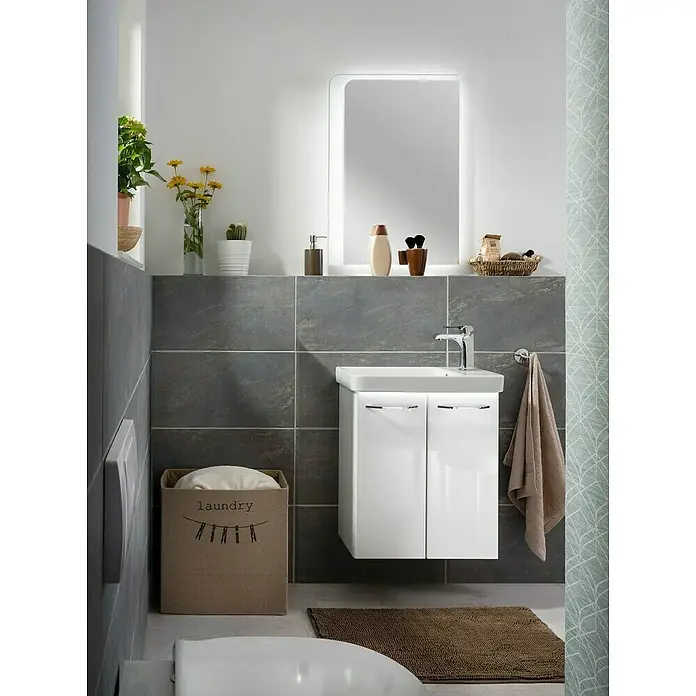Fackelmann Milano Waschbeckenunterschrank - B x T x H: 520 x 275 x 610 mm, Weiß - Ein modernes Badezimmer mit einem beleuchteten Spiegel, einem weißen Waschtischunterschrank und einem Wäschekorb.