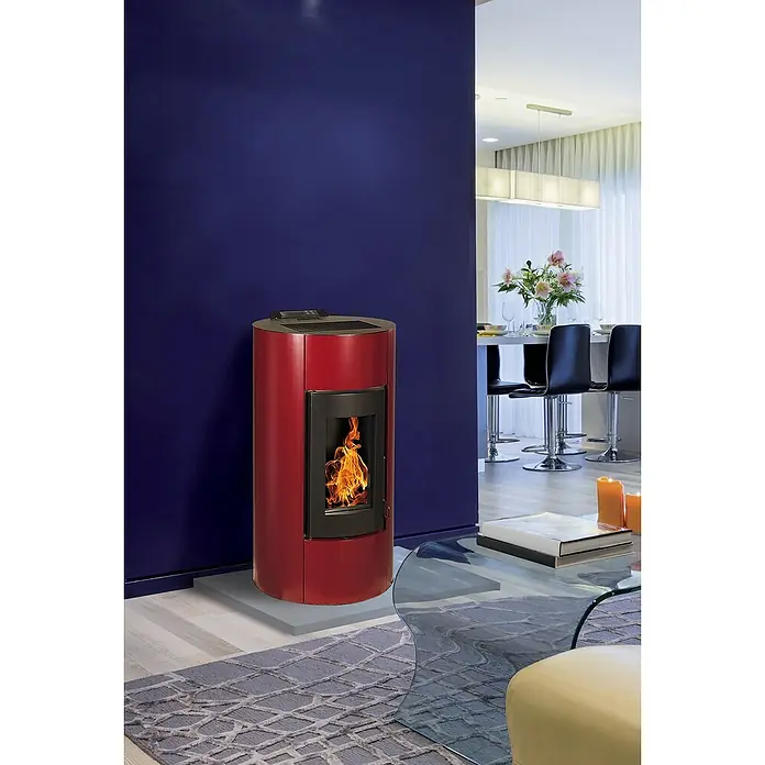 Pelletofen Angelina - 8,9 kW, Raumheizvermögen: 250 m³, 0,73 kg/h - 1,96 kg/h, Farbe Verkleidung: Bordeaux - Ein rot lackierter Pelletofen sorgt für Wärme und Behaglichkeit im modern eingerichteten Wohnzimmer mit blauer Akzentwand.