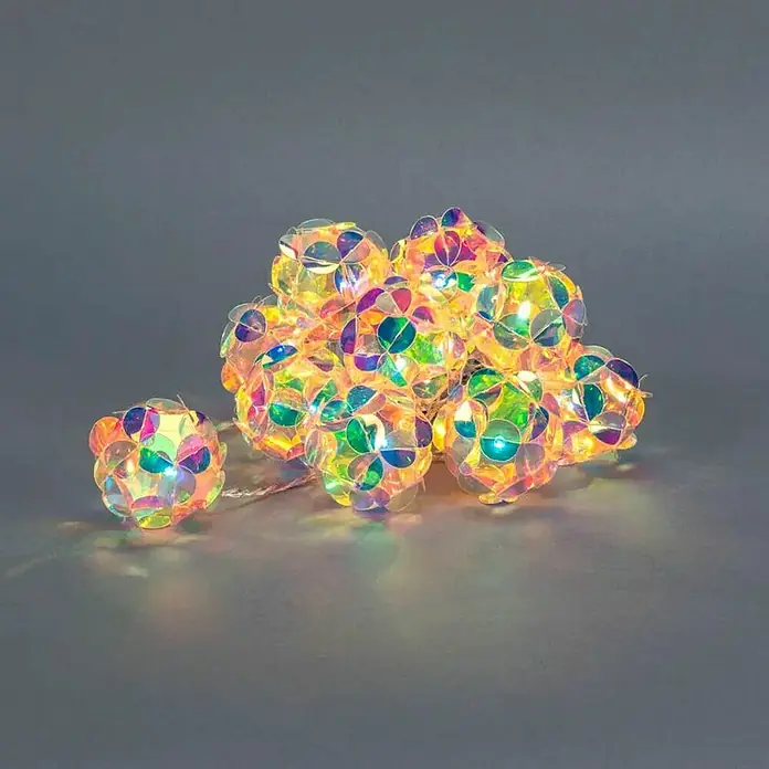 Konstsmide LED-Lichterkette - Innen, Lichtfarbe: Warmweiß, Anzahl Leuchtmittel: 10 Stk., Batteriebetrieben, LED - Nahaufnahme einer Lichterkette mit irisierenden Kugel Lampen, die ein warmes, funkelndes Licht auf einem grauen Hintergrund ausstrahlen.