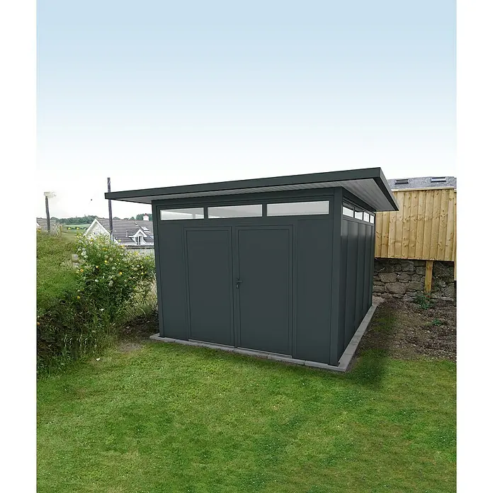Wismar-NFI Gerätehaus Trefle 34 - Außenmaß inkl. Dachüberstand (B x T): 425 x 525 cm, Stahl, Anthrazit/Weiß - Grauer Gartenschuppen mit Doppeltüren, Oberlichtern und Flachdach auf einem grünen Rasen.