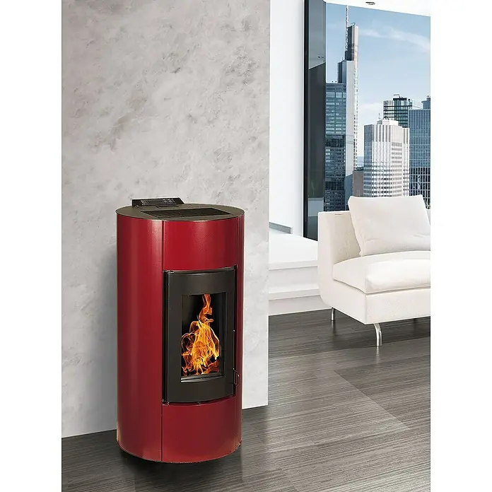 Pelletofen Angelina - 11,4 kW, Raumheizvermögen: 320 m³, 0,73 kg/h - 2,5 kg/h, Farbe Verkleidung: Bordeaux - Roter Pelletofen im modernen Wohnzimmer mit Blick auf die Stadt, der Wärme und Stil vereint.