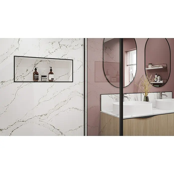 Wetwall Wandpaneel Alloy Spritzschutz - 25 x 80 cm, Calacatta Volegno - Ein modernes Badezimmer mit weißen Waschbecken, ovalen Spiegeln und einer eingelassenen Ablage mit stilvollen Pflegeprodukten.