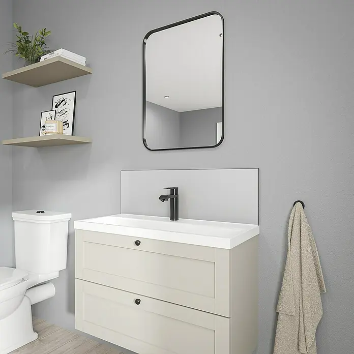 Wetwall Wandpaneel Alloy Spritzschutz - 25 x 80 cm, Glacier White / Neptune Blue - Dieses Badezimmer-Interieur zeigt einen modernen Waschtisch mit Schubladen, einen Spiegel und eine Toilette in einem hellen, minimalistischen Design.