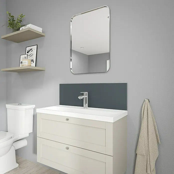 Wetwall Wandpaneel Alloy Spritzschutz - 25 x 80 cm, Malibu Grey / Storm Blue - Ein helles Badezimmer mit einem Waschbeckenunterschrank, einem Spiegel und einer Toilette. Die schwebenden Regale bieten zusätzlichen Stauraum.