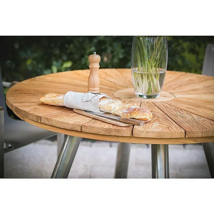 Kai Wiechmann Gartentisch - Ø x H: 130 x 78 cm, Teakholz, Rund, Naturbelassen - Ein rustikaler Holztisch mit Baguette, Gewürzmühle und Vase. Der Tisch aus Massivholz eignet sich perfekt für den Außenbereich.