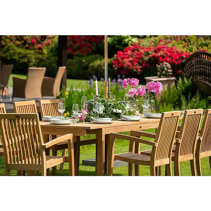 Kai Wiechmann Gartentisch - L x B x H: 180 x 90 x 76 cm, Teak, Rechteckig, Naturbelassen - Eine elegante Gartentisch- und Stuhl-Kombination aus Holz, dekoriert mit Blumenarrangements und Geschirr, die eine einladende Atmosphäre schafft.