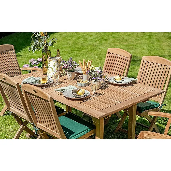 Kai Wiechmann Gartentisch - L x B x H: 240 x 120 x 75 cm, Teak, Rechteckig, Naturbelassen - Gartentisch-Szene mit Holzmöbeln, Gedeck und Blumenarrangements, die eine einladende Atmosphäre für Mahlzeiten im Freien schaffen.