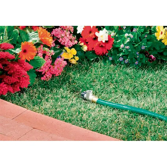 Soporte de estaca para aspersor - L x An x Al: 8,5 x 3,4 x 21 cm - Una manguera de jardín verde con un accesorio metálico ajustable ubicada en el césped junto a un jardín de flores.