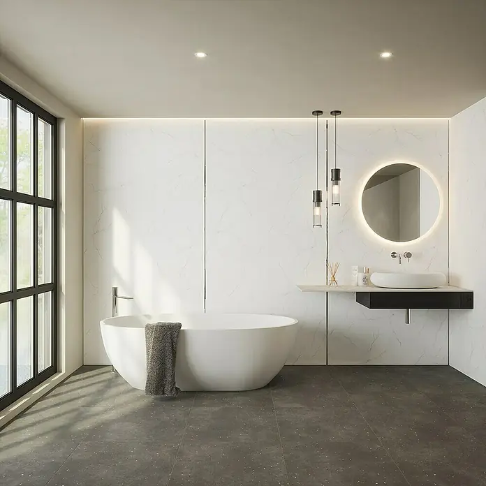 Wetwall Wandpaneel Alloy - 60 x 244 cm, Bianco Venato - Ein modernes Badezimmer mit einer freistehenden Badewanne und einem beleuchteten Spiegel über einem eleganten Waschtisch.