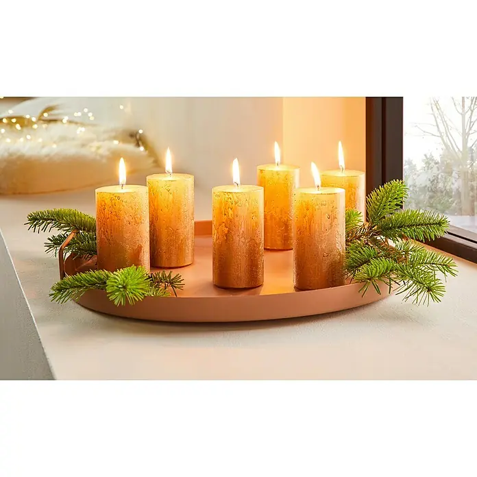 Stumpenkerze Nova Safe - Ø x H: 7 x 14 cm, Antikgold - Kerzen auf einem Teller: Festliche Stimmung mit goldenen Kerzen und Tannenzweigen auf einem dekorativen Teller, ideal für die Adventszeit.