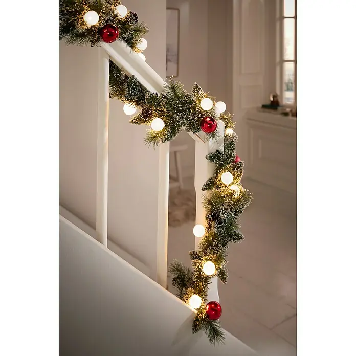 Edelmann Weihnachtsgirlande Kaprun - Kunststoff, LED-Beleuchtung - Festliche Treppendekoration mit einer Tannengirlande, roten Kugeln und warm leuchtenden Kugellichtern.
