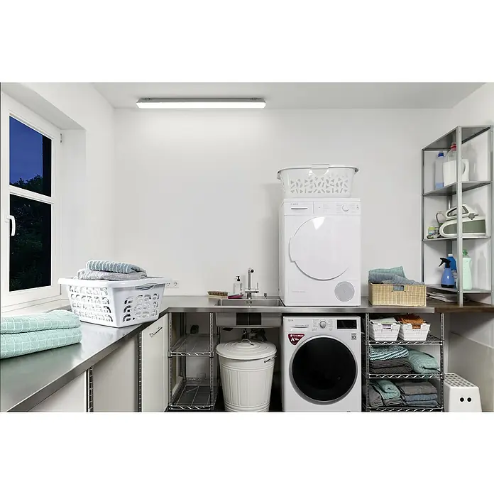 Osram Feuchtraumleuchte Submarine - Länge: 120 cm, Lichtfarbe: Neutralweiß, 36 W, IP65 - Waschküche mit Waschmaschine und Trockner. Der Raum verfügt über einen hellen Arbeitsbereich mit Regalen, Waschbecken und Ablageflächen.