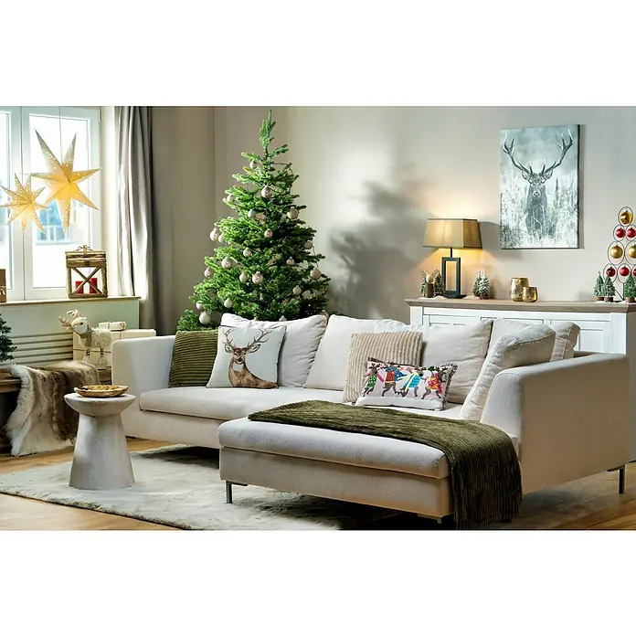 Edelmann Künstlicher Weihnachtsbaum Maklura - Höhe: 185 cm, Grün - Festliche Wohnzimmerdekoration mit beigem Sofa, Weihnachtsbaum und Hirschmotiven für eine gemütliche Atmosphäre.
