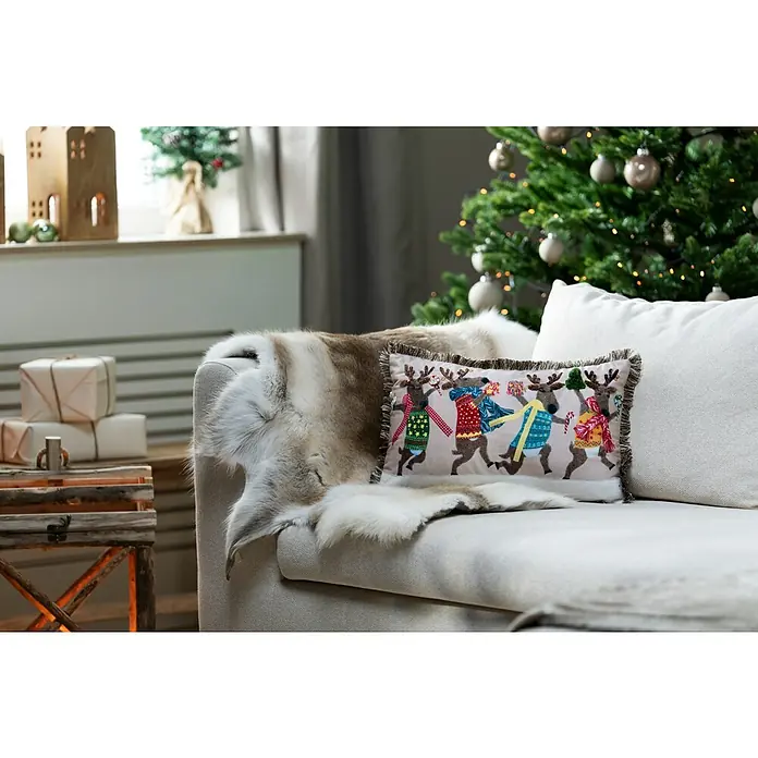 Kissen Rentiere - Weihnachten, 50 x 30 cm, 100 % Polyester - Dekokissen mit Rentier-Motiv auf einem Sofa mit Fell, weihnachtliche Atmosphäre.