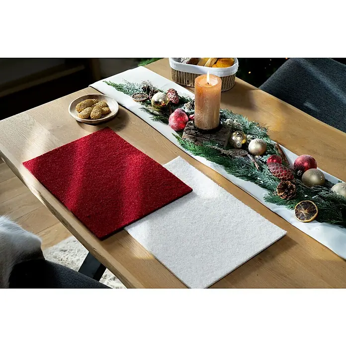 Platzset - 1 Stk., Sortiert, 28 x 38 cm - Tischdekoration mit Filzuntersetzern in Rot und Weiß neben einem festlichen Gesteck mit Kerze, ideal für eine gemütliche Weihnachtsatmosphäre.