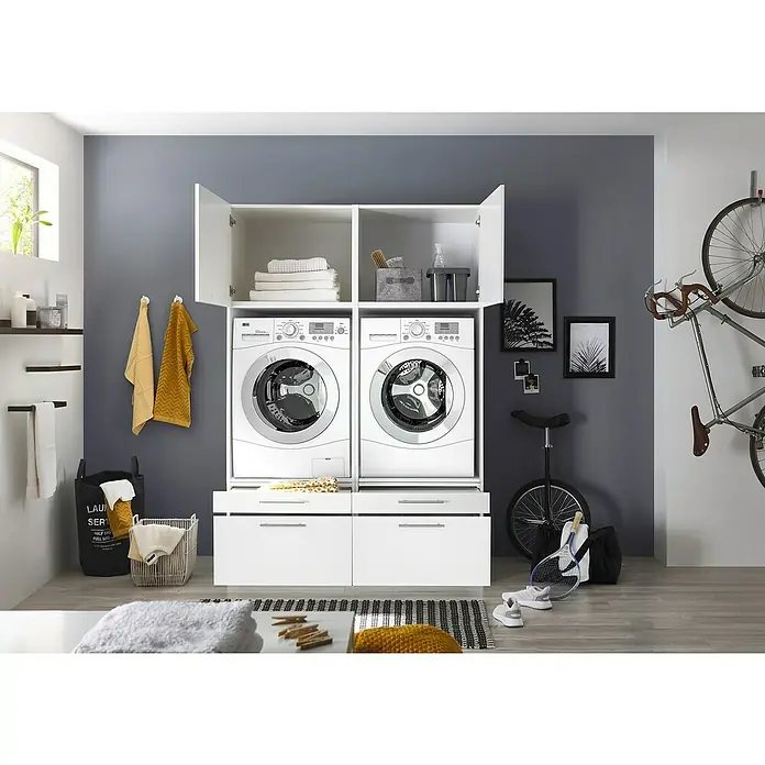 Respekta Waschmaschinenschrank Clara - L x B: 67,6 x 134,8 cm, Weiß, Mit zwei Waschmaschinenschränken - Das Bild zeigt einen modernen Waschraum mit übereinander gestapelten Waschmaschine und Trockner, umgeben von weißen Schränken und Ablageflächen.