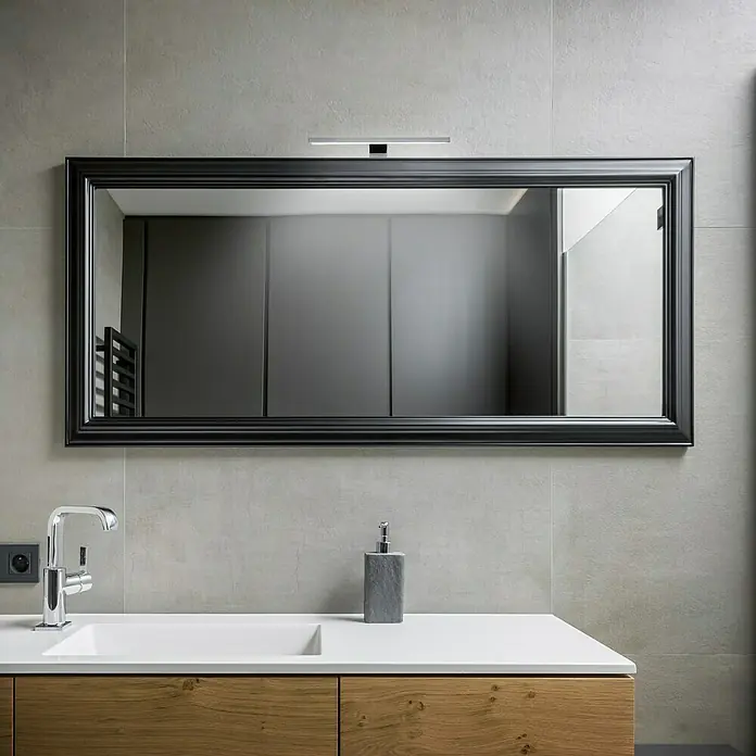 Briloner Aplique LED para espejo - 5 W, L x An x Al: 30 x 10,3 x 3,6 cm, Cromo, Blanco neutro - Un baño con un espejo rectangular con marco negro y una lámpara encima, acompañado de un lavabo, un grifo y un dispensador de jabón.