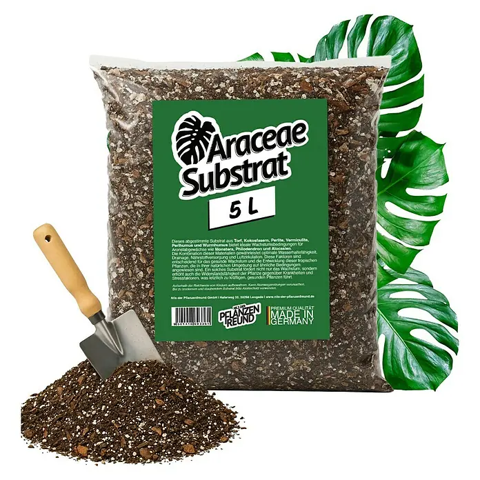 Pflanzensubstrat Araceaesubstrat - 5 l - Ein Sack Araceae-Substrat, eine spezielle Erdmischung für Aronstabgewächse wie Monstera, Philodendron und Alocasia, mit Schaufel und Monstera-Blättern im Hintergrund.
