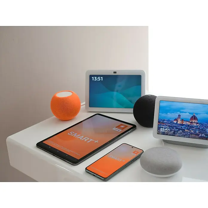 Osram Smart+ Smart-Steckdose matter - Innen, Weiß, 2 Stk. - Verschiedene Smart-Home-Geräte, darunter Tablets, Smartphones und Smart Speaker, auf einer weißen Oberfläche.