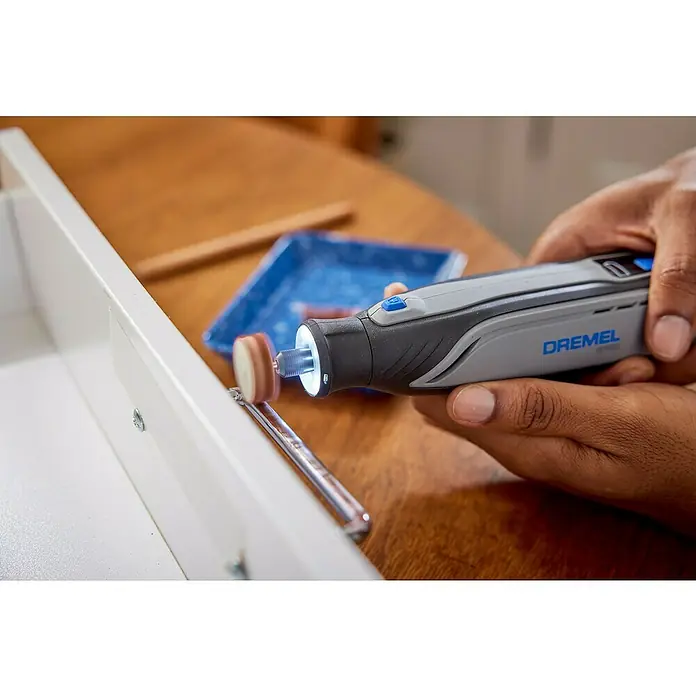 Dremel Akku-Multifunktionswerkzeug 8150-20 - 7,2 V, 1 Akku, 2 Ah - Eine Person verwendet ein Dremel-Werkzeug, um einen Schrankgriff zu polieren, wobei der Fokus auf dem Dremel-Multifunktionswerkzeug liegt.