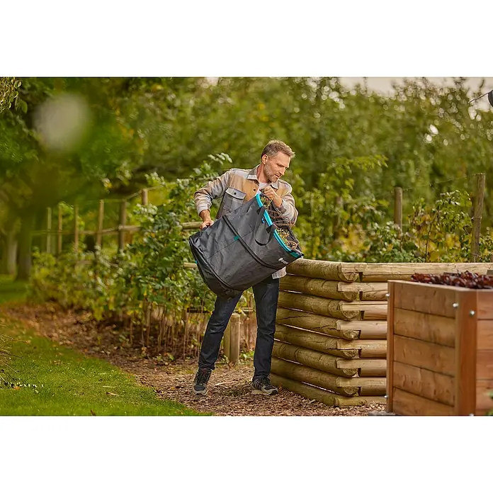 Gardena Pop-Up Gartenabfallsack Rechteck L - 220 l - Ein Mann leert einen Gartensack von Gardena in einen Komposthaufen. Praktischer Gartensack zum einfachen Transportieren von Gartenabfällen.