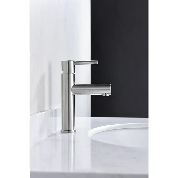 Imex Moscú Grifo de lavabo - Cromo, Resplandeciente - Un moderno grifo de acero inoxidable en un tocador de mármol blanco con líneas limpias y un diseño minimalista.