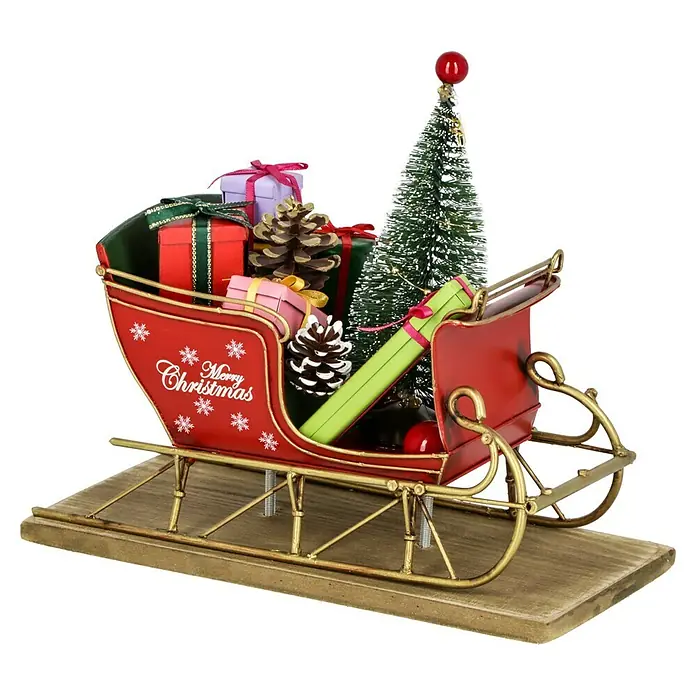 Dekofigur Weihnachtsschlitten - L x B x H: 22 x 10,5 x 18 cm, Metall - Ein festlicher roter Weihnachtsschlitten, beladen mit Geschenken, Kiefernzapfen und einem kleinen Weihnachtsbaum auf einem Holzsockel.