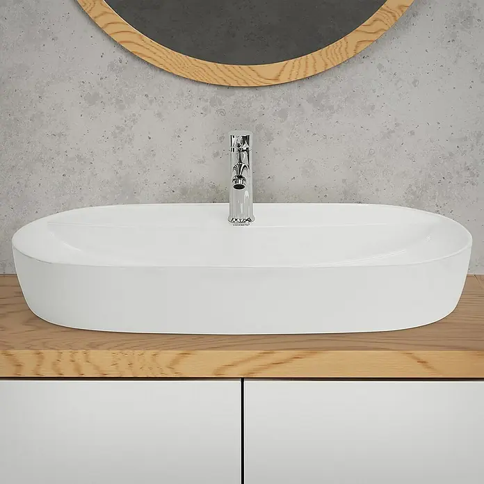 LuxeBath Aufsatzwaschbecken Oval 80x40x12 cm Weiß Ablaufgarnitur Weiß - Hahnloch: Mitte, Ohne Überlauf, Weiß - Modernes Badezimmer-Waschbecken mit ovaler Form und Armatur auf einem Unterschrank. Der Spiegel an der Wand rundet das Bild ab.