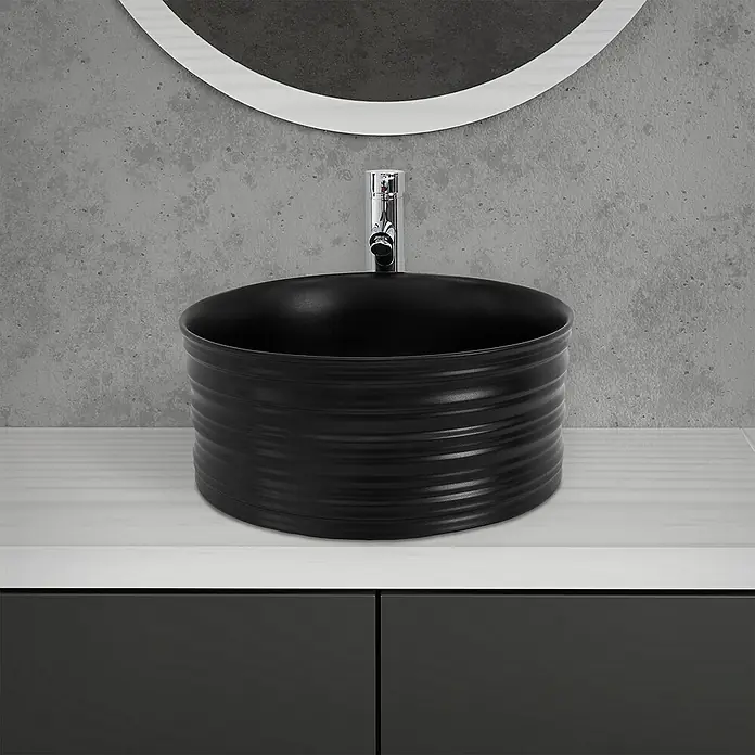 LuxeBath Aufsatzwaschbecken Rund Ø41x18 cm Schwarz Ablaufgarnitur Schwarz - Ohne Spezialglasur, Schwarz - Elegantes Badezimmerwaschbecken in Schwarz mit gerippter Textur und moderner Armatur vor einem Spiegel und einer grauen Wand.