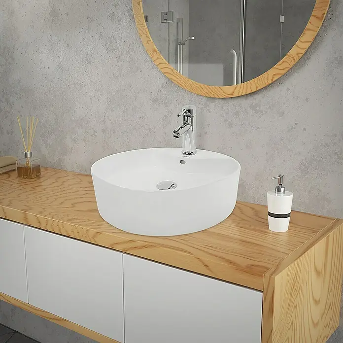 LuxeBath Aufsatzwaschbecken Aufsatzwaschtisch Handwaschbecken inkl. Ablaufgarnitur mit Überlauf - Mit Überlauf, Weiß - Das Bild zeigt ein modernes Waschbecken mit Armatur auf einem hölzernen Waschtisch. Ein runder Spiegel hängt an der Wand über dem Becken.