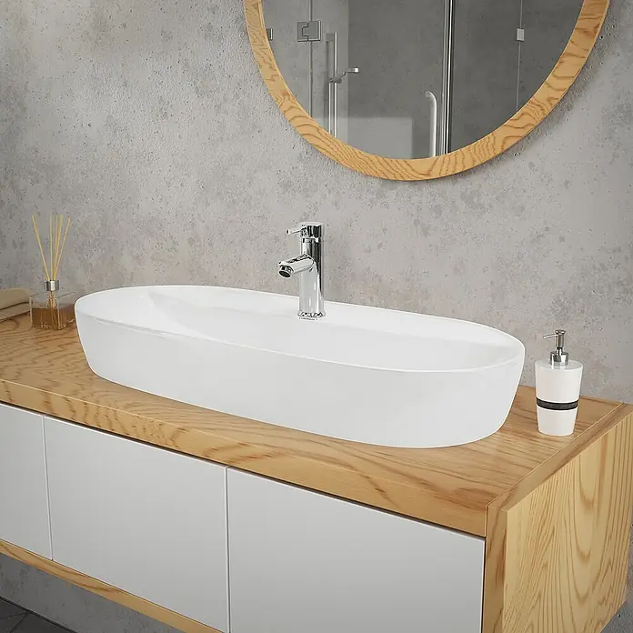 LuxeBath Aufsatzwaschbecken Handwaschbecken Weiß inkl. Ablaufgarnitur ohne Überlauf - Hahnloch: Mitte, Ohne Überlauf, Weiß - Nahaufnahme eines modernen Badezimmers mit einem länglichen Waschbecken, Armatur und einem runden Spiegel an der Wand.