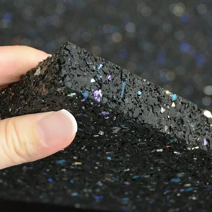 Floordirekt Unterlagsmatte Antivibrationsmatte 60 x 60 x 1 cm - 0,36 m², Stärke: 10 mm - Detailaufnahme einer schwarzen Gummimatte mit farbigen Sprenkeln, die Textur und Beschaffenheit des Bodenbelags hervorhebt.