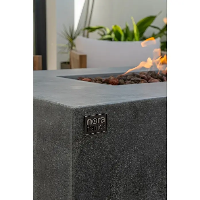 Nora Flames Estufa de exterior Misti - 16 kW, L x An x Al: 140 x 70 x 58 cm, Gris - Primer plano de un brasero Nora Flames con llamas y rocas de lava, ideal para espacios exteriores elegantes y tardes.