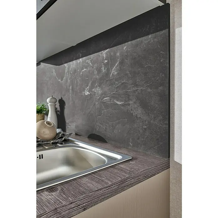 LOGOCLIC Küchenrückwand Fixmaß - Black Concrete/Elara Grey, 410 x 64 cm, Stärke: 13,4 mm - Nahaufnahme einer Edelstahlspüle in einer modernen Küche mit dunkler Arbeitsplatte und passendem Spritzschutz.