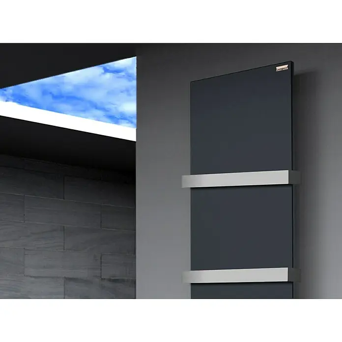 Szagato Designheizkörper Manhattan 3 - B x H: 470 x 1.800 mm, Wärmeleistung bei Vorlauftemperatur von 75 °C (D: 50): 1.118 W, Anthrazit, Mit 2 Handtuchhalter (50 mm) - Wandmontierter Handtuchwärmer mit silbernen Halterungen vor grauer Wand und Fenster mit Himmelsblick.