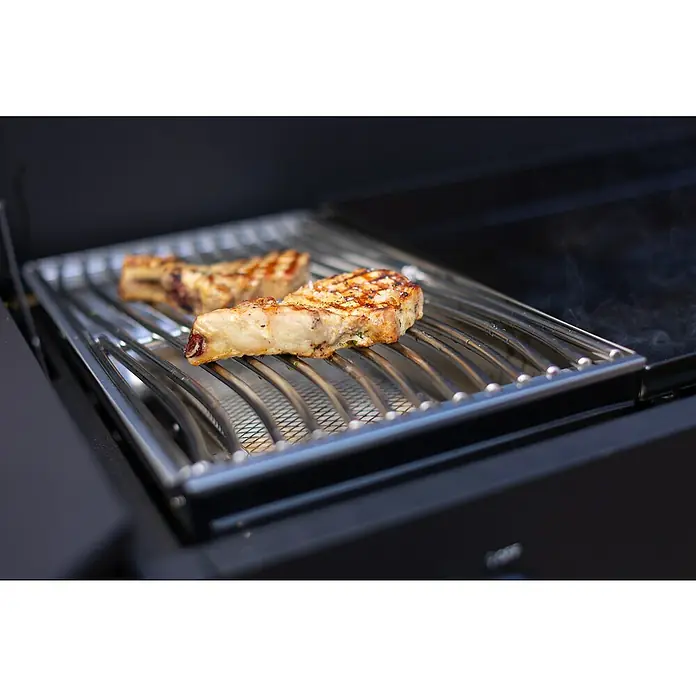 Cozze Plancha-Grill Combo 900 - Grillfläche (B x T): 79,3 x 46,3 cm, 7,5 kW, Anzahl Brenner: 3 Stk. - Gegrillte Schweinekoteletts auf einem Grillrost, die eine köstliche Mahlzeit versprechen. Das Fleisch ist saftig und perfekt zubereitet.