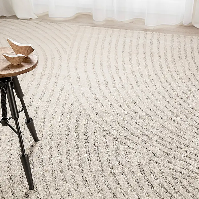 Dekoria Flachgewebeteppich - creme, beige - Nahaufnahme eines stilvollen, beigen Teppichs mit einem wellenförmigen Muster, das eine moderne und elegante Ästhetik verleiht.