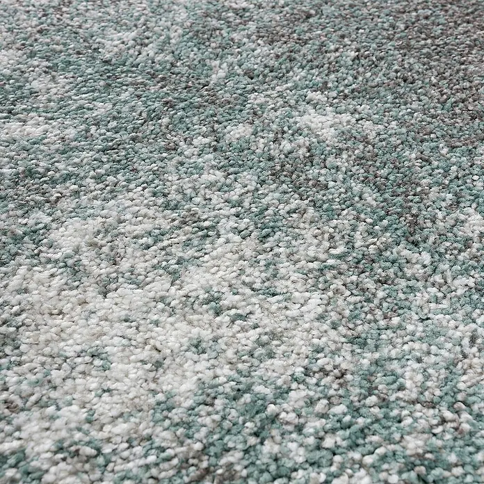 Dekoria Flachgewebeteppich - grau, grün, creme, 230 x 160 cm - Detailaufnahme eines Teppichs mit unregelmäßigem Muster in Weiß-, Grau- und Türkistönen. Die Textur ist weich und flauschig.