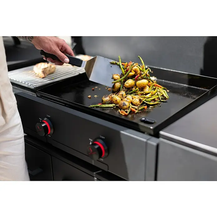 Cozze Plancha-Grill Combo 900 - Grillfläche (B x T): 79,3 x 46,3 cm, 7,5 kW, Anzahl Brenner: 3 Stk. - Grillplatte in Aktion: Gemüse und Kartoffeln werden mit einem Spatel gewendet. Die präzise Temperaturregelung sorgt für perfekte Ergebnisse.