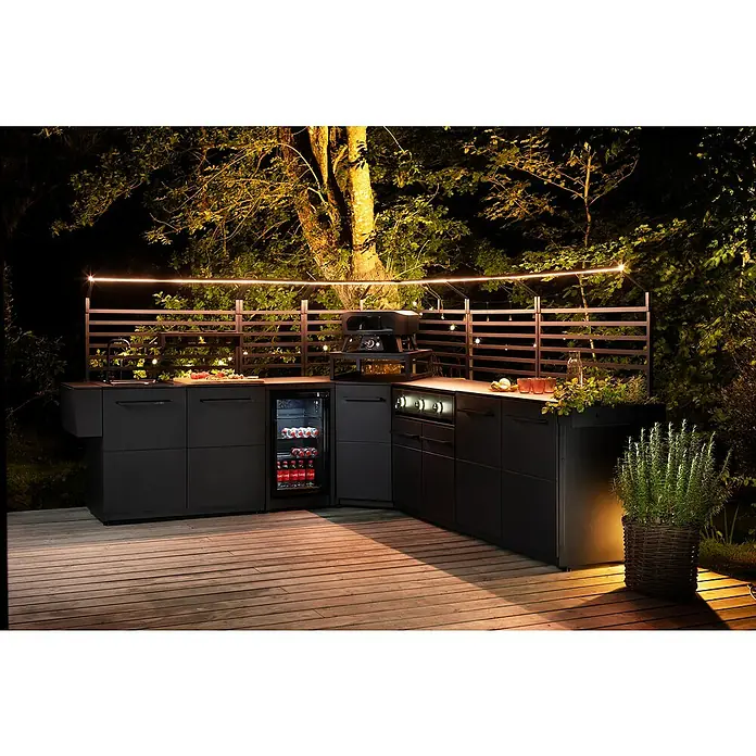 Cozze Elements Halterung für Lichtschlauch - Breite: 110 cm, Stahl/Aluminium, Passend für: Cozze Elements Rückwand - Moderne Outdoor-Küche mit Grill, Spüle und Kühlschrank auf einer Holzterrasse, stimmungsvoll beleuchtet für gemütliche Abende im Freien.