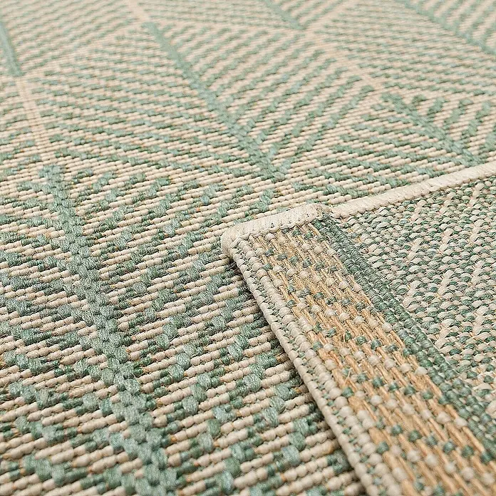 Dekoria Flachgewebeteppich - grün, 170 x 120 cm - Detailansicht eines hellen Teppichs mit geometrischem Muster und umgeschlagener Ecke, der die Webstruktur zeigt.