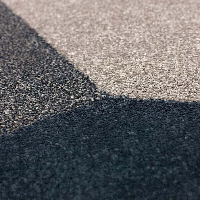 Dekoria Flachgewebeteppich - grau, dunkelblau, 290 x 200 cm - Nahaufnahme eines Teppichs mit geometrischem Muster in Grau- und Schwarztönen, der eine moderne und stilvolle Optik bietet.\n