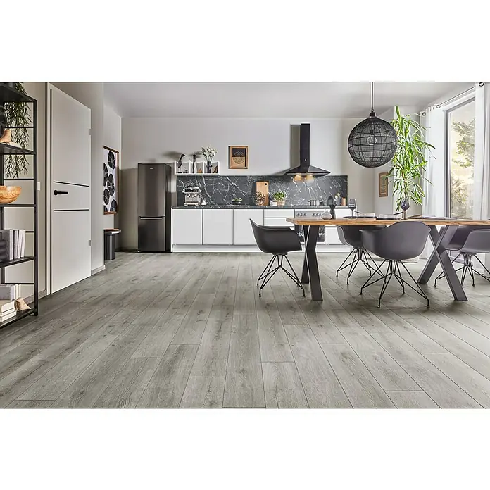 LOGOCLIC Aquaprotect Smart Silent Laminat - Calais Oak, Landhausdiele, 1.288 x 195 x 7 mm - Helle, moderne Küche mit grauem Holzboden, Esstisch mit schwarzen Stühlen, weißen Küchenschränken und einem großen Kühlschrank. Eine stilvolle und einladende Atmosphäre.
