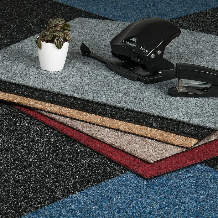 Bricoflor Teppichfliese - Breite: 50 cm, Nadelfilz, Polypropylen, grau - Produktbild mit Locher, Hefter, Pflanze und Teppichfliesen in verschiedenen Farben.