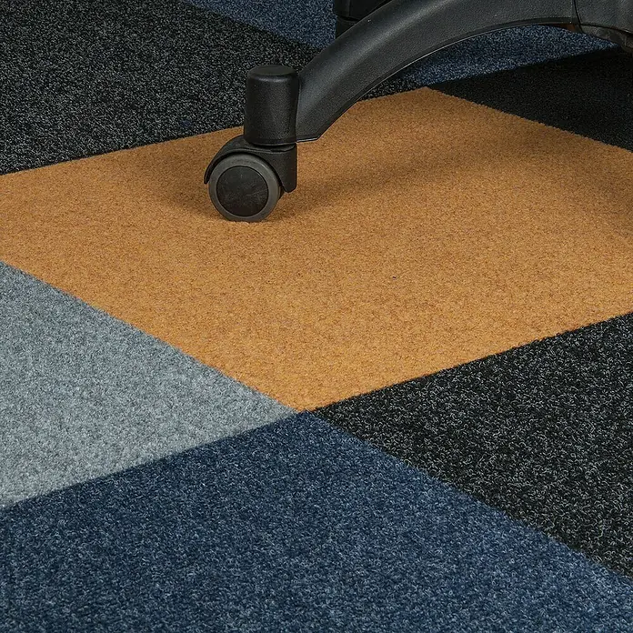 Bricoflor Teppichfliese - Breite: 50 cm, Nadelfilz, Polypropylen, grau - Detailaufnahme eines Bürostuhls auf einem Teppich mit geometrischen Mustern, der eine moderne Büroatmosphäre schafft.