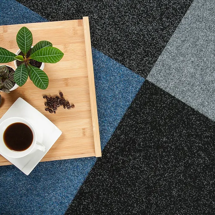 Bricoflor Teppichfliese - Breite: 50 cm, Nadelfilz, Polypropylen, anthrazit - Ein Holztablett mit einer Tasse Kaffee, Kaffeebohnen und einer Pflanze auf einem Teppich mit geometrischem Muster.