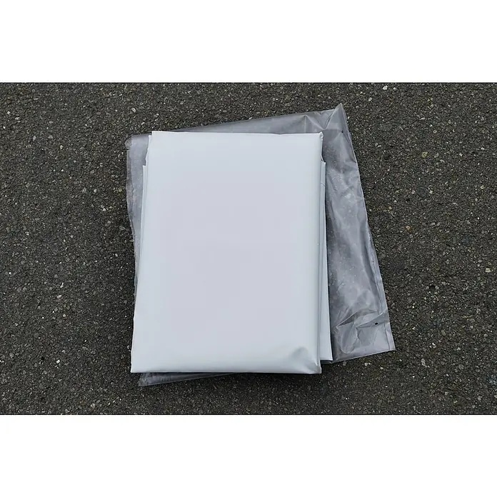 Stema Flachplane BH 7.5-20-12.1 - Passend für: Stema PKW-Anhänger BH 7.5-20-12.1 mit Kasteninnenmaß 201 x 117 cm - Verpackte weiße Plane auf rauem Untergrund, ideal für Abdeckungen und Schutz im Außenbereich.