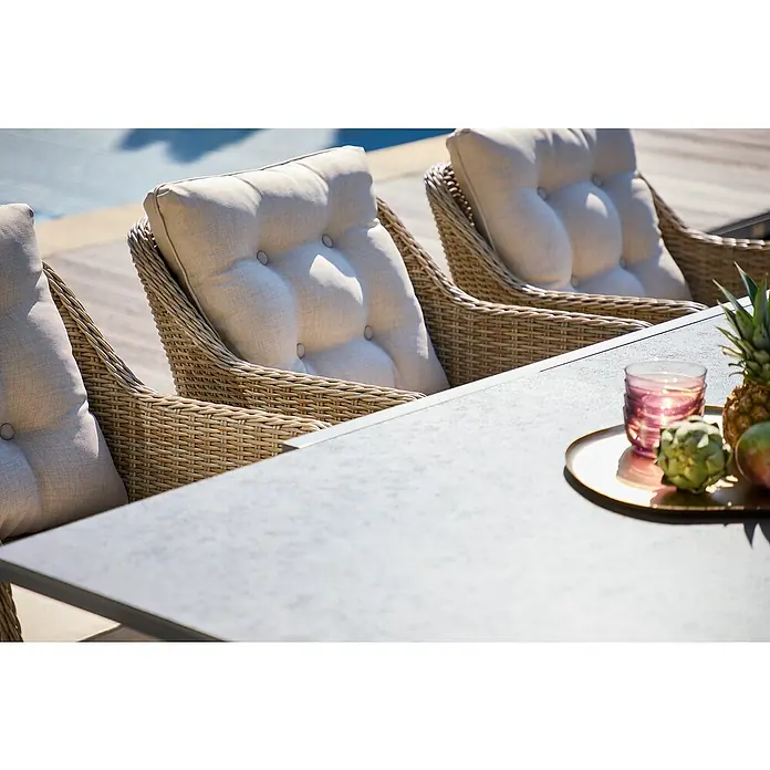 Sunfun Pauline Gartensessel - Polyrattan, Aluminium, Hellbraun, B x T x H: 63 x 70 x 84 cm - Nahaufnahme von Outdoor-Korbsesseln mit beigen Polstern und einem Tisch mit dekorativen Elementen.