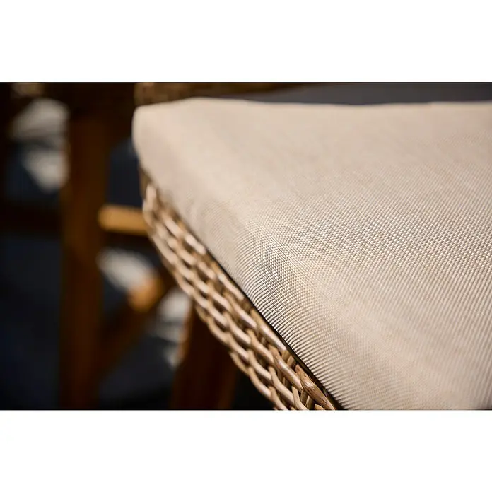 Sunfun Pauline Gartensessel - B x T x H: 62 x 70 x 80 cm, Polyrattan, Akazie, Aluminium, Hellbraun - Nahaufnahme eines Rattanstuhls mit beigefarbenem Stoffkissen. Das Detail zeigt die Textur des Kissens und das Geflecht des Stuhls.